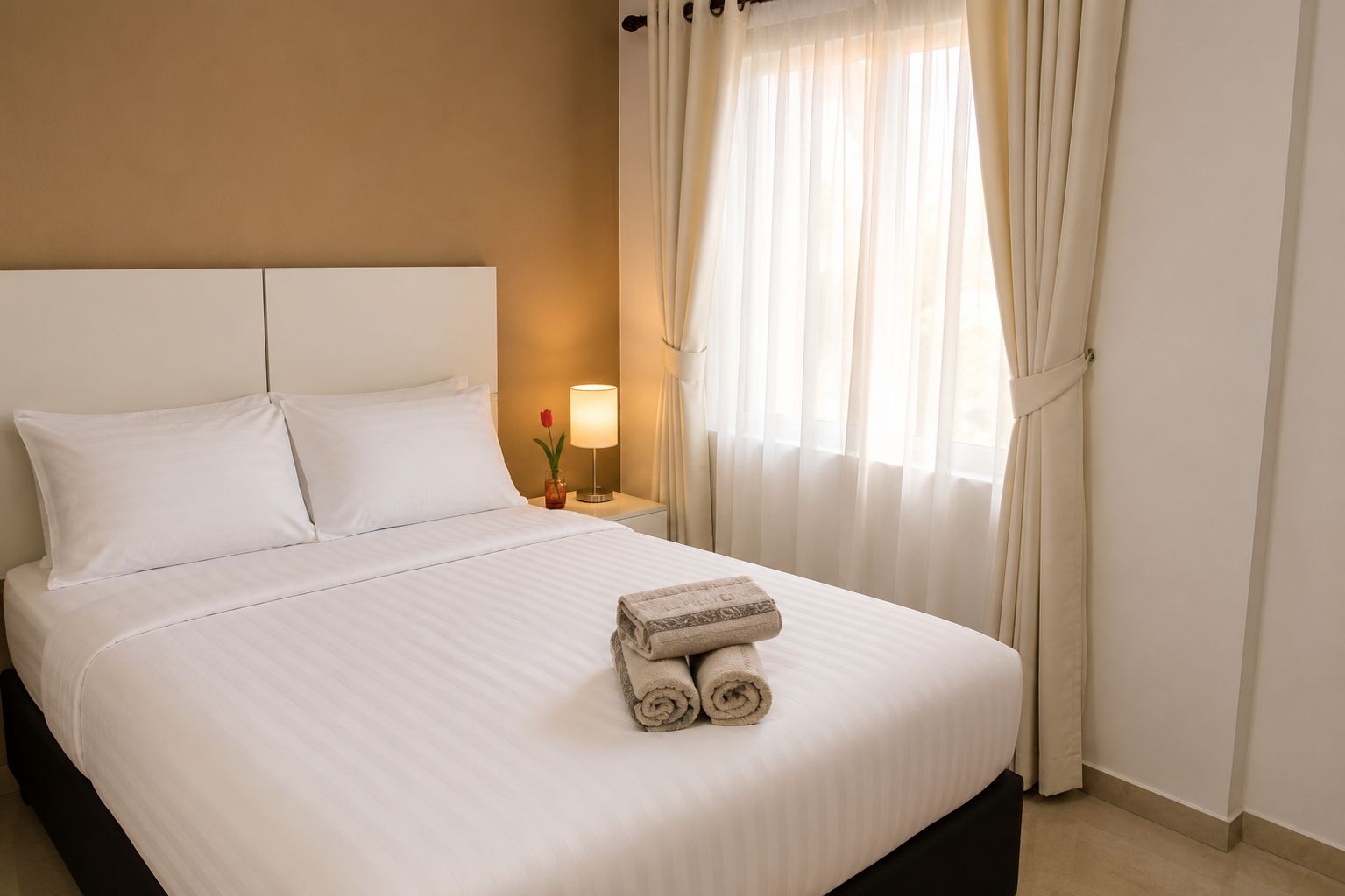 Suíte de hostel limpa com cama de casal arrumada, TV de tela plana e ar-condicionado